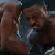 Jonathan Majors punching Michael B. Jordan in Creed III.